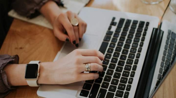 A woman's hands on a laptop's keyboard